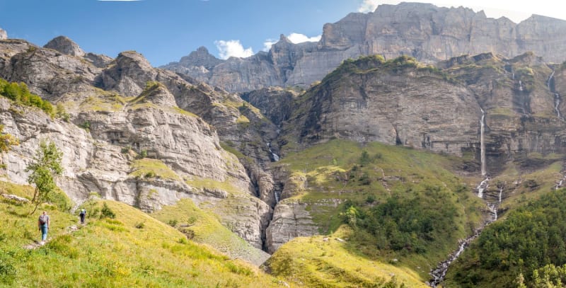 Randonnée cascade Haute-Savoie : deux randonneurs allant vers la cascade du Fer à Cheval, dans un cirque de montagne