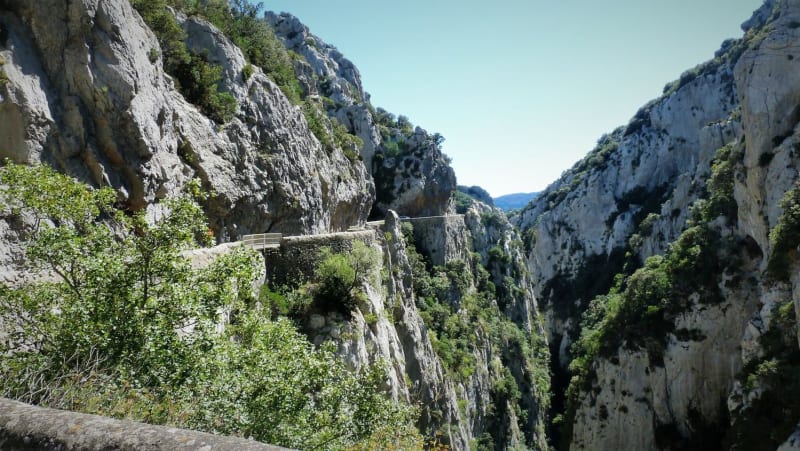 Randonnée gorges de Galamus : route dans faille rocheuse calcaire et buissonneuse