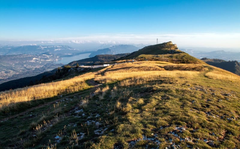 Randonnée Grand Colombier : sommet herbeux vert et jaune dominant vallée