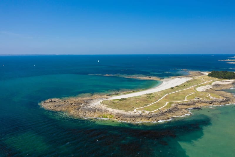 Randonnée pointe du Conguel : pointe de terre avec herbe et sable entourée d'eau bleue