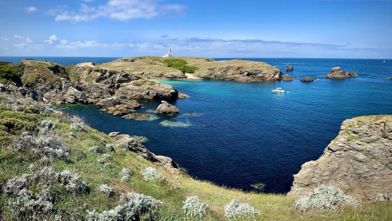 Randonnée pointe des Poulains : falaises rocheuses entourées d'eau bleue