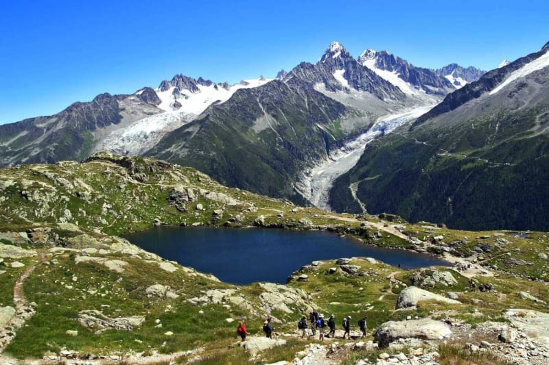 Randonnées lacs des Chéserys : étendue d'eau entourée de roche verdoyante et de montagnes saupoudrées de neige