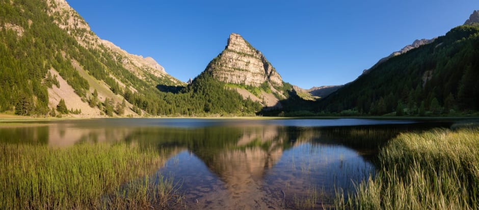 Randonnée lac des Sagnes : étendue d'eau au pied d'un mont pointu