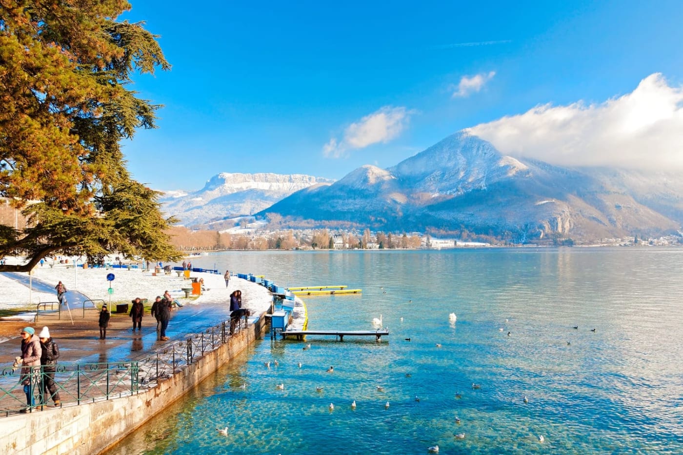 Le lac d'Annecy entouré de montagnes enneigées en hiver