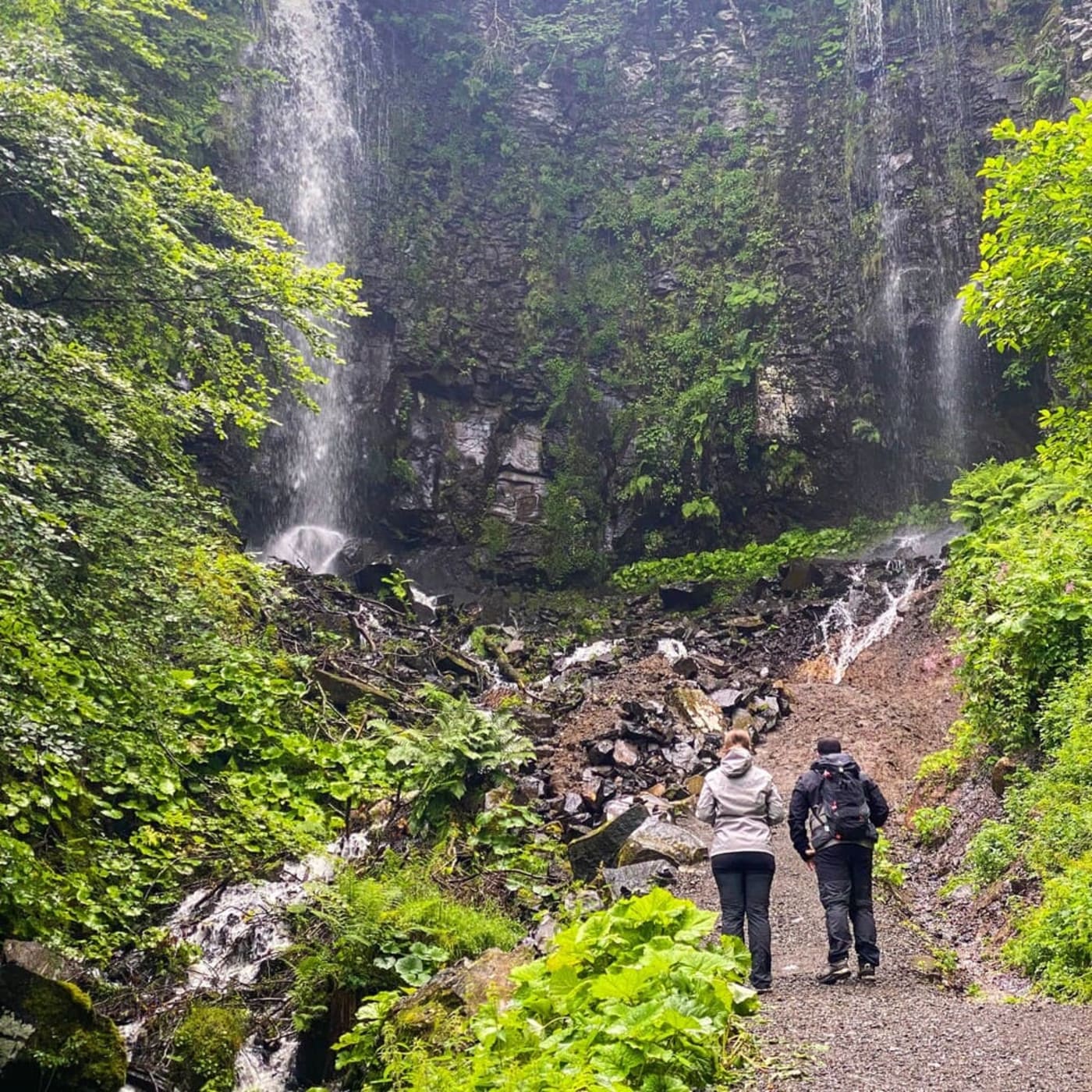 Randonnée cascade du Saut du Loup Auvergne : deux randonneurs au pied de la cascade tombant sur les falaises