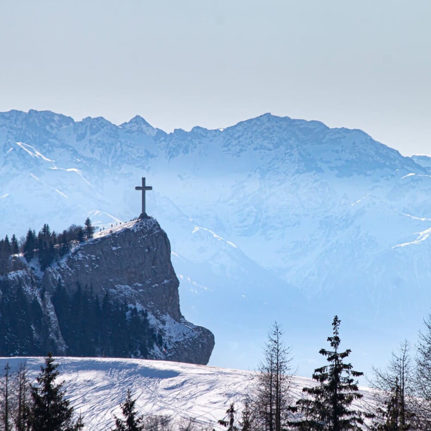 Randonnée raquettes à la croix du Nivolet en Savoie : vue sur la Croix en hiver et la chaîne de l'Epine dans la distance