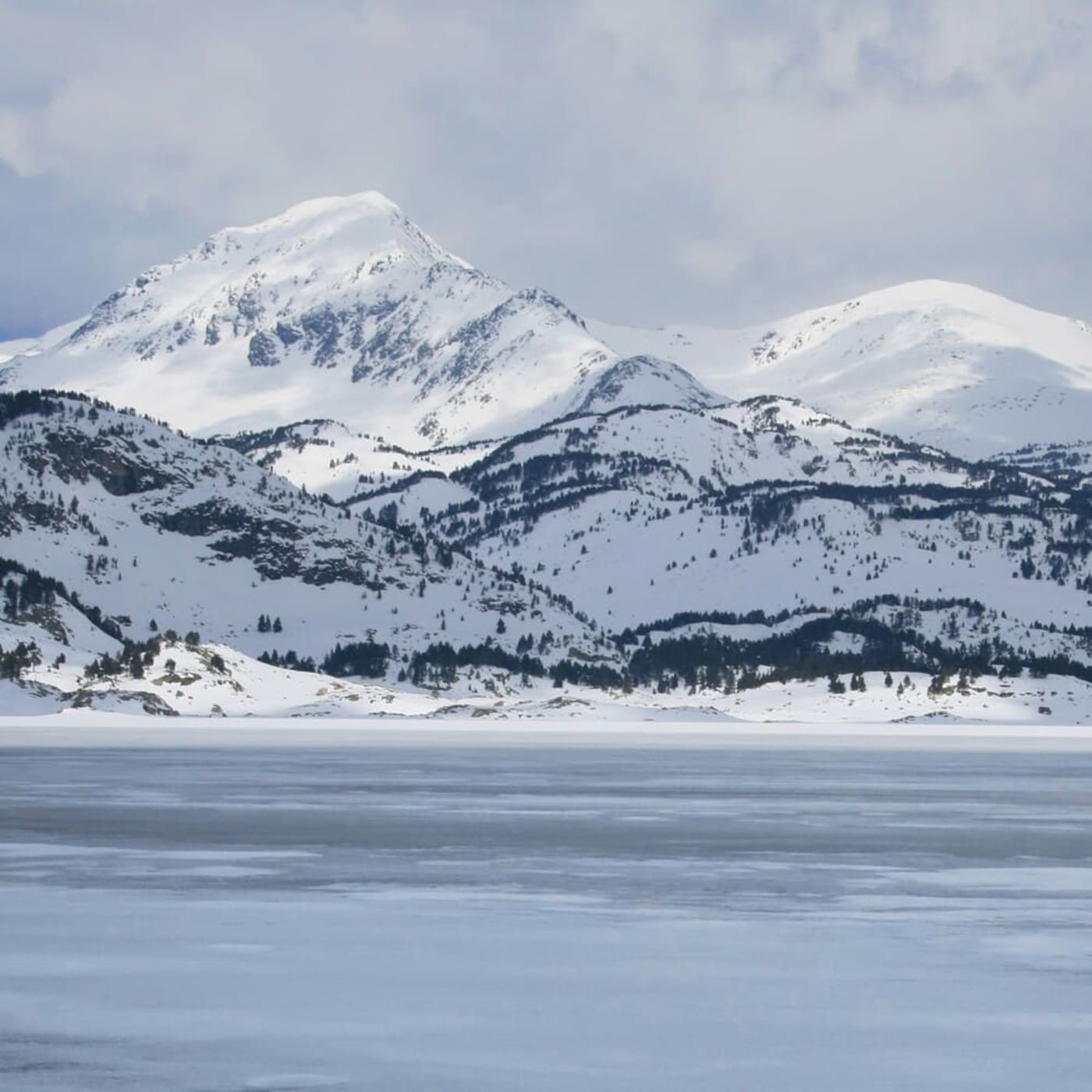 Randonnée raquettes Pyrénées : vue sur le lac des Bouillouses enneigé autour de Font-Romeu