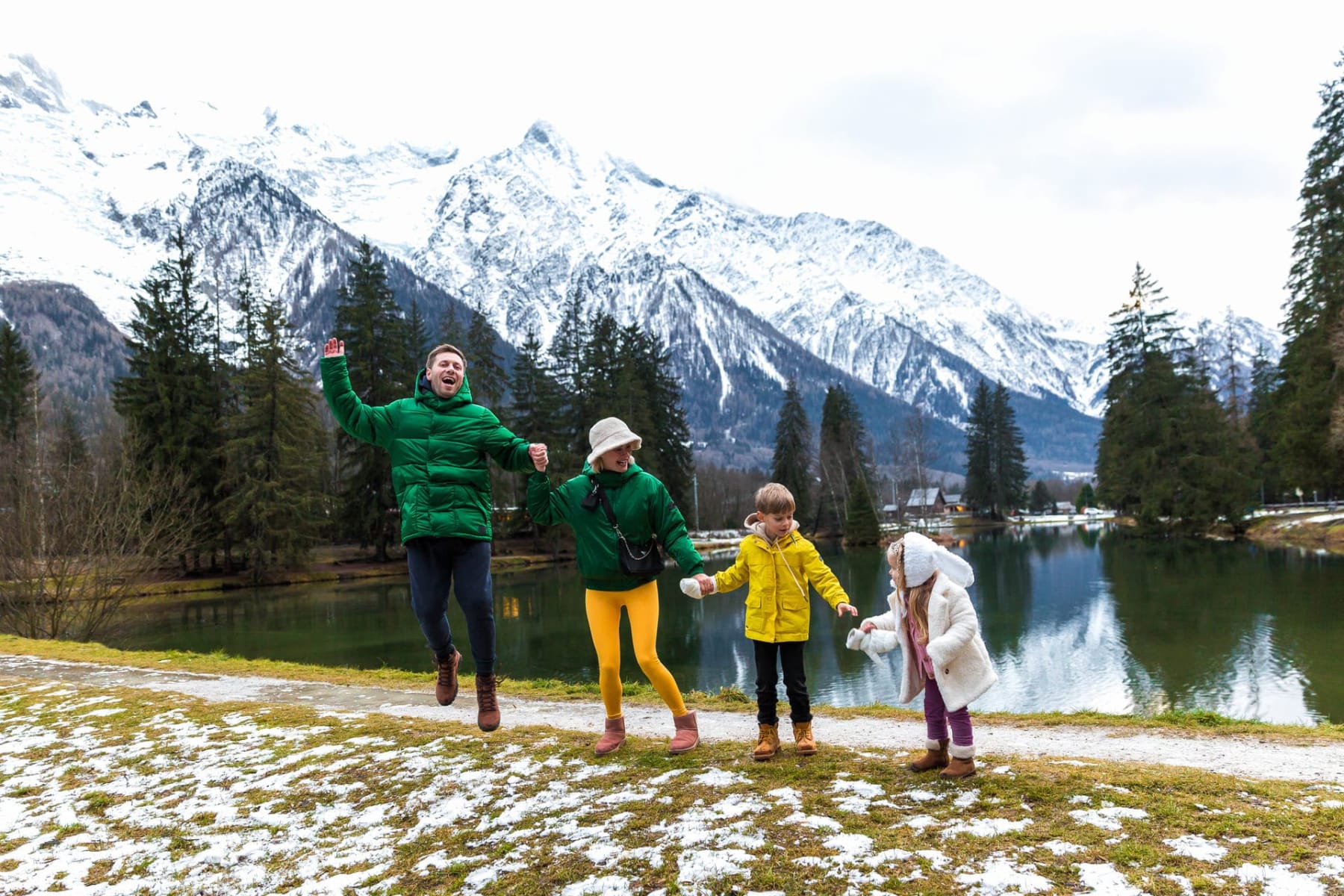 Randonnées famille Chamonix : famille de quatre au bord d'un lac avec les montagnes enneigées autour