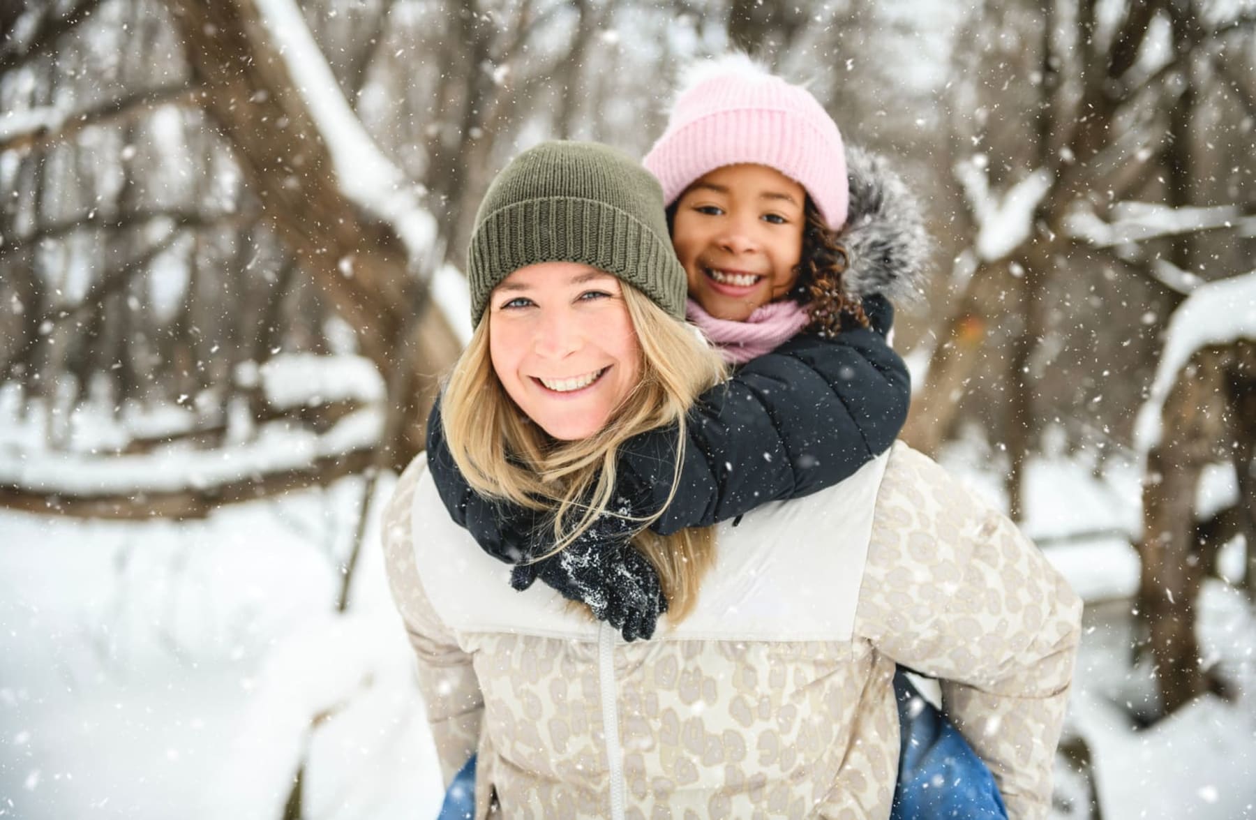 Mère et sa fille sur le dos s'amusant dans la neige