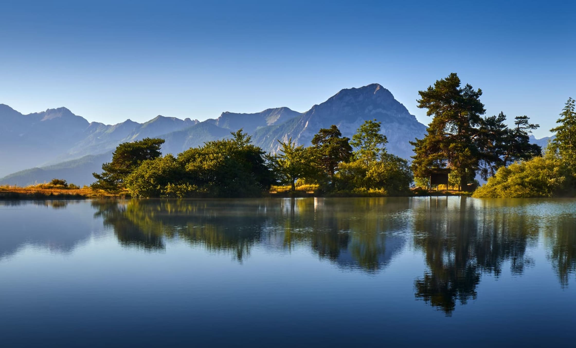 Lac Saint-Apollinaire : les mélèzes et les montagnes se reflètent dans l'eau