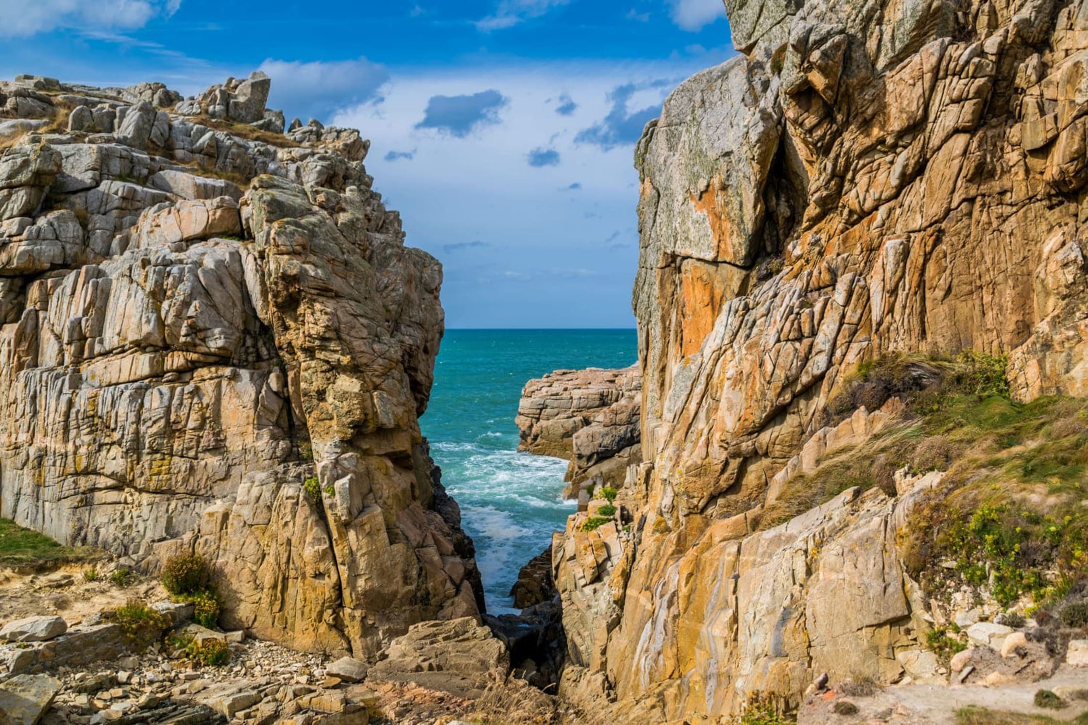 Randonnée gouffre de Plougrescant : faille rocheuse avec vue sur la mer turquoise et le ciel bleu