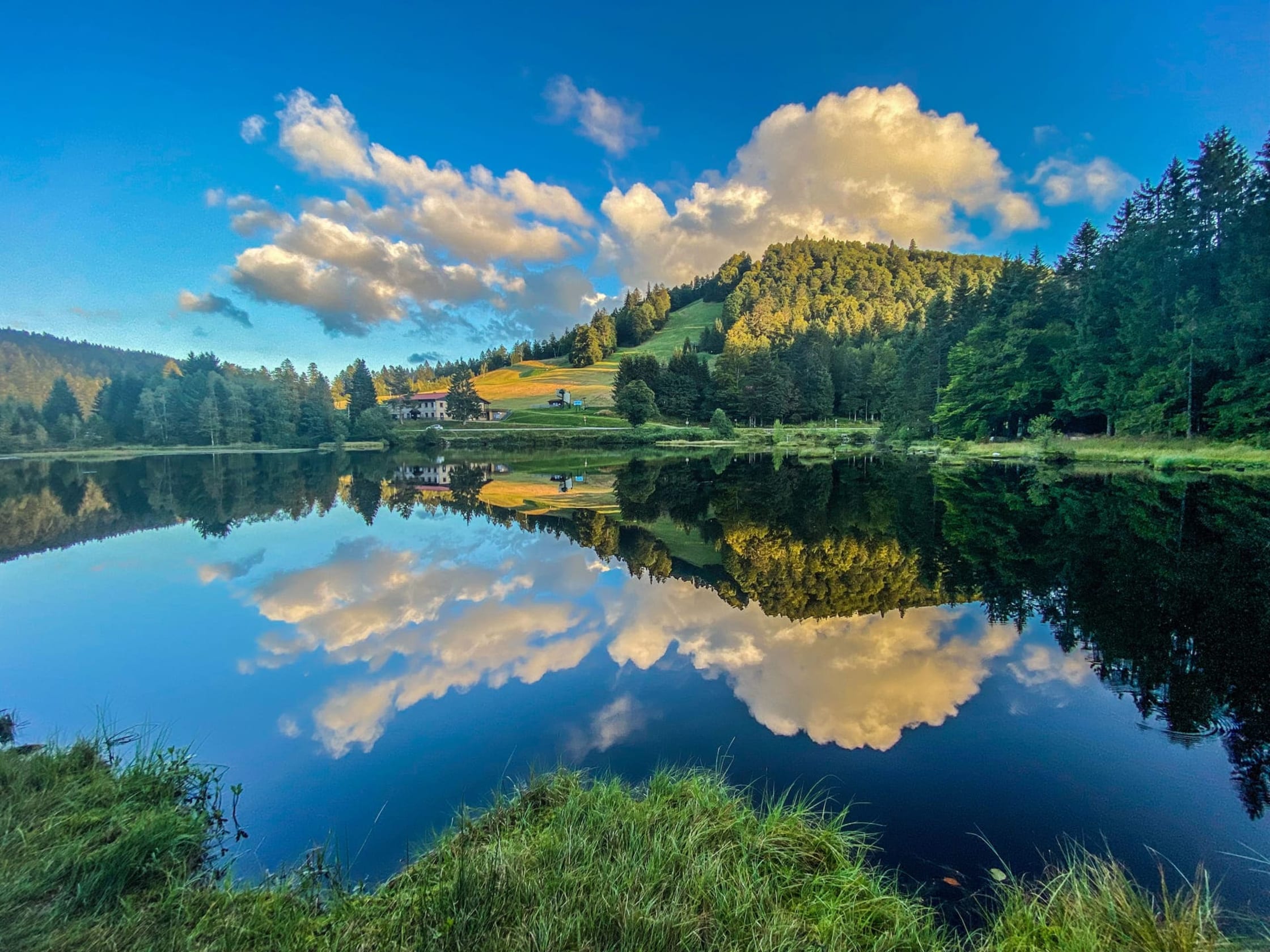 Randonnée lac de Lispach : étendue d'eau lisse , végétation verte autour, reflet sur l'eau