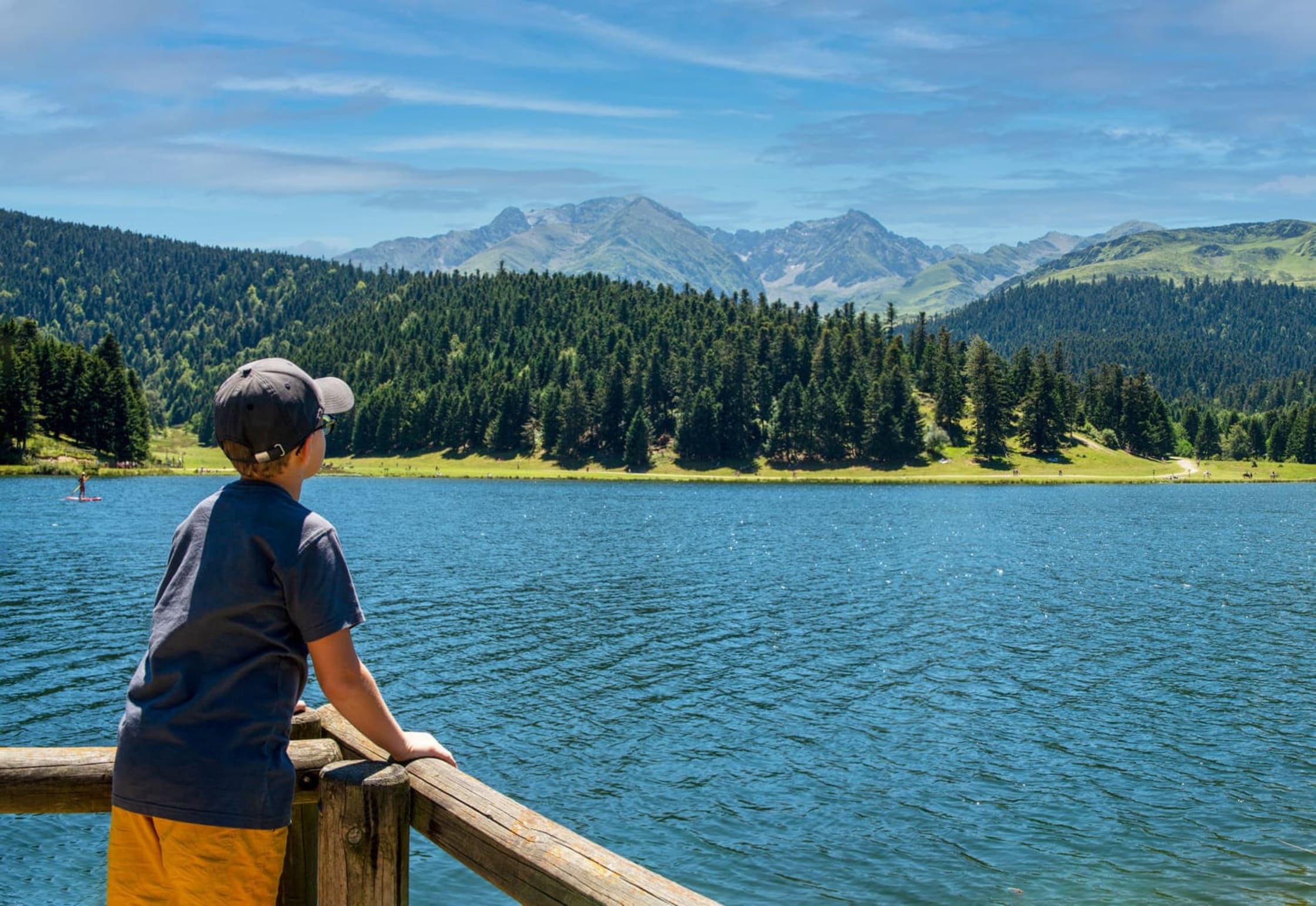 Un enfant regarde le lac de Payolle et ses montagnes