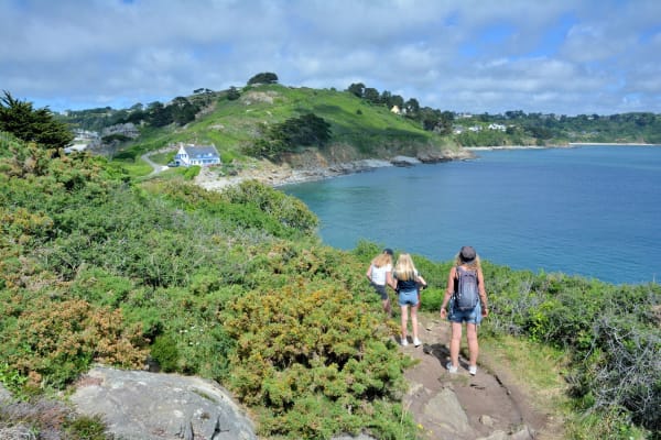 Randonnée pointe de Bihit : enfants sur le sentier côtier bordé de buissons verts et mer bleue