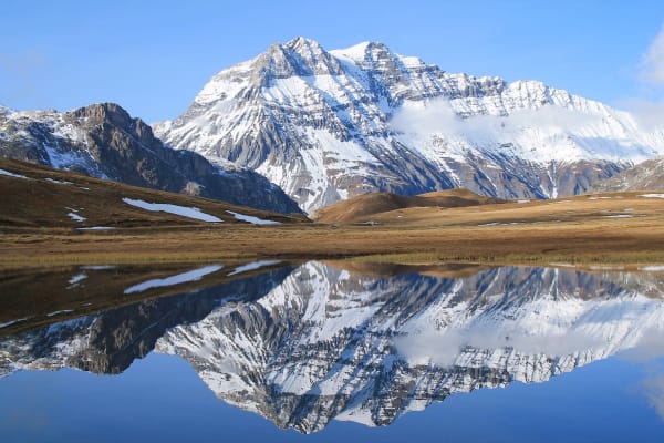 Auvergne-Rhône-Alpes : montagne enneigée reflétant sur un lac