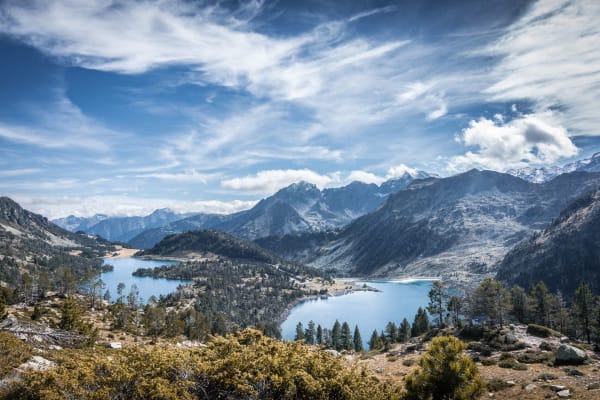 Occitanie : lac entouré de sommets montagneux et de végétation