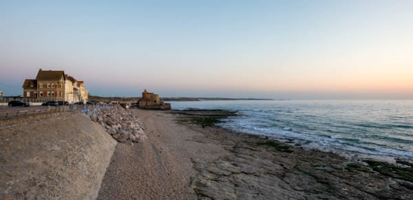 Hauts-de-France : bord de plage de sable avec bâtiment et coucher de soleil