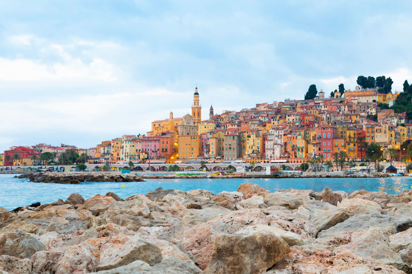 Rochers, mer bleue et maisons colorées sur colline