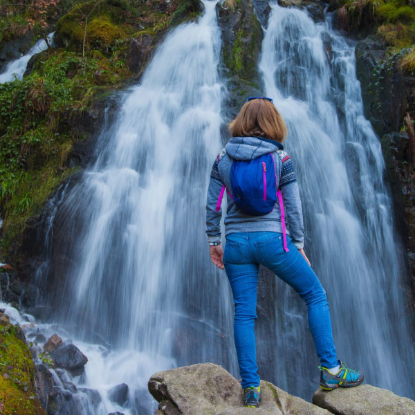 Une randonneuse devant la grande cascade de Tendon dans les Vosges