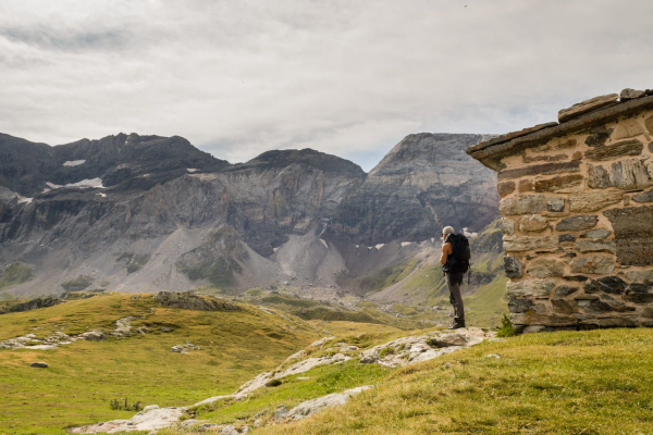 Un randonneur observe le cirque de Troumouse devant la cabane de la Vierge