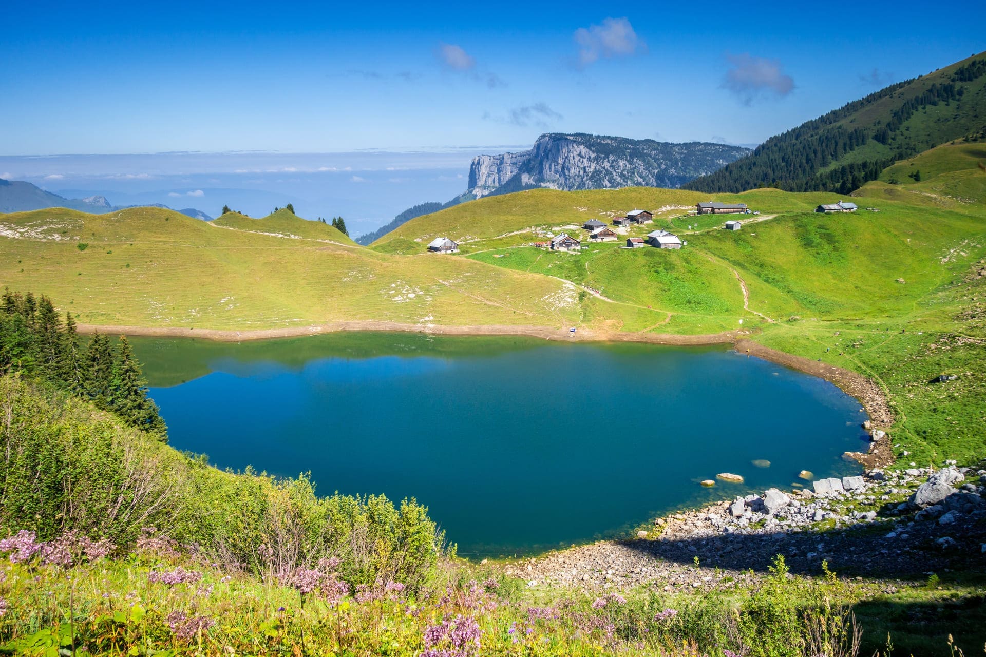 Randonnée lac de Lessy : étendue d'eau entourée d'herbes et d'un refuge