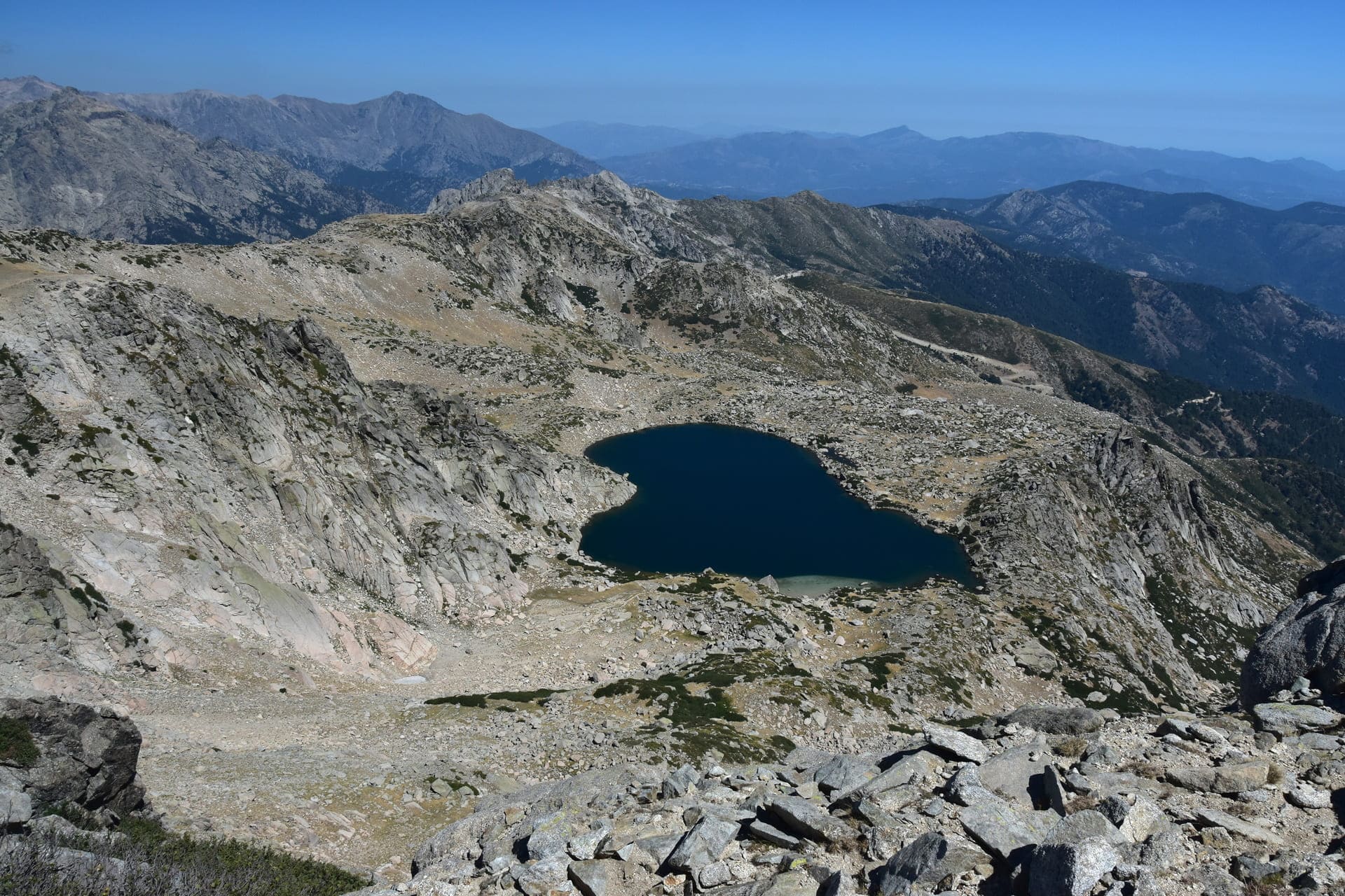 Randonnée lac de Bastani : lac en forme de cœur et montagnes rocheuses autour