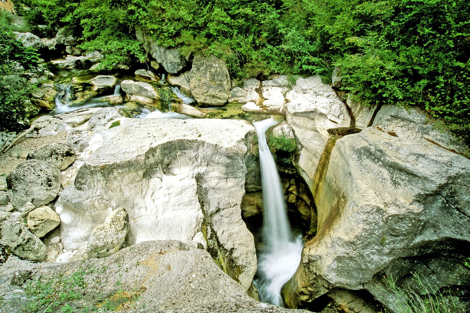 Randonnée gorges du Loup : cascade tombant dans un trou créé par la roche