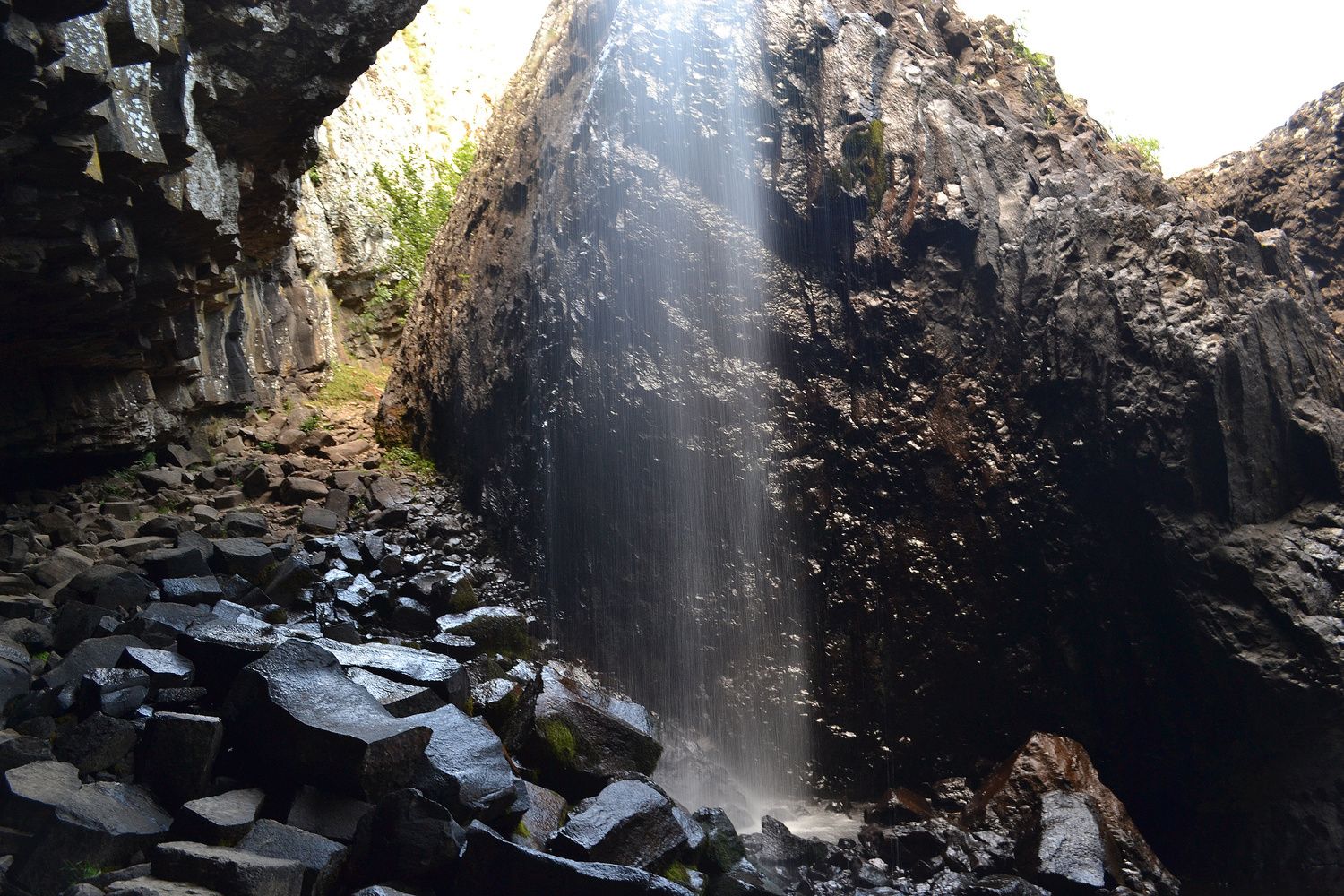 Grotte et orgues basaltiques sous la cascade du Déroc en Lozère.