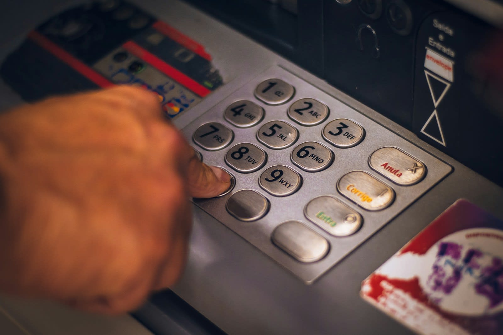 A finger pressing keys on a payment terminal.