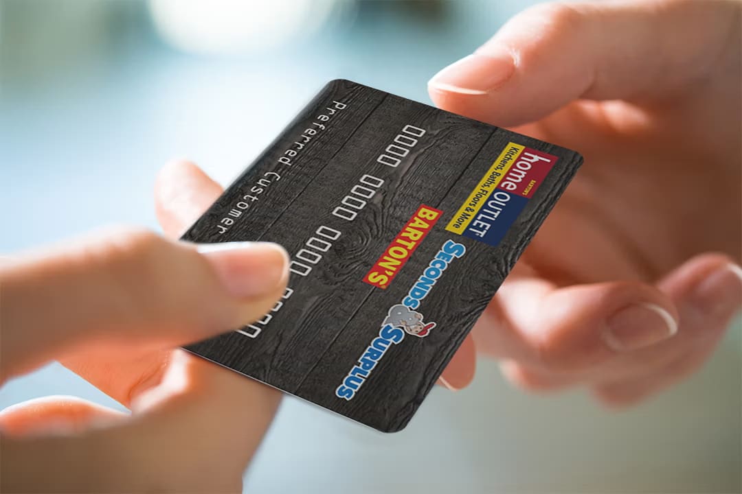 Cashier handing a customer a Home Outlet credit card. 