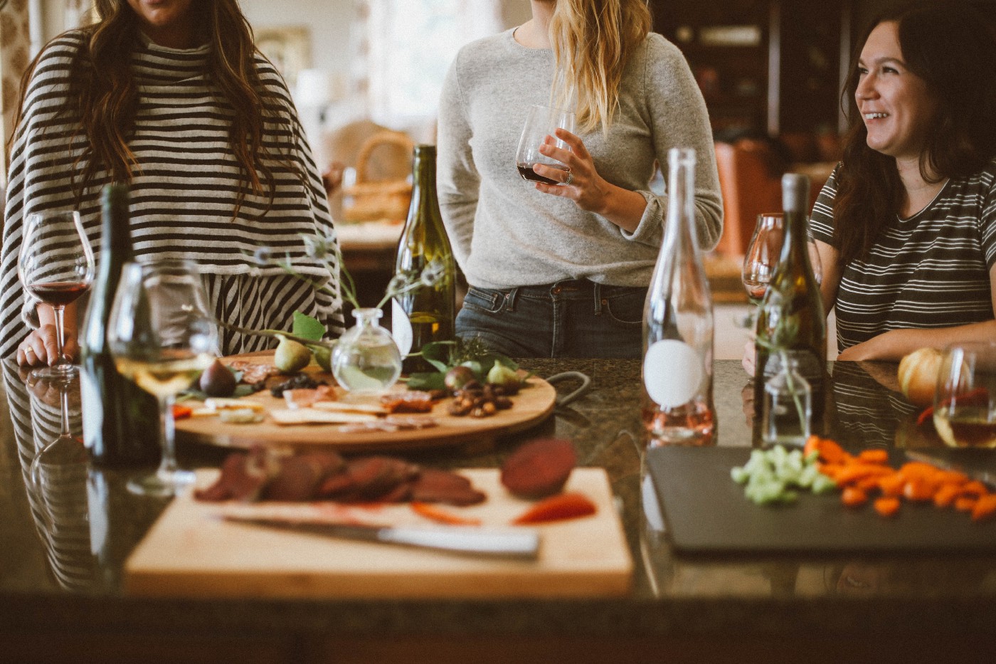 Three women drinking wine around a dinner table