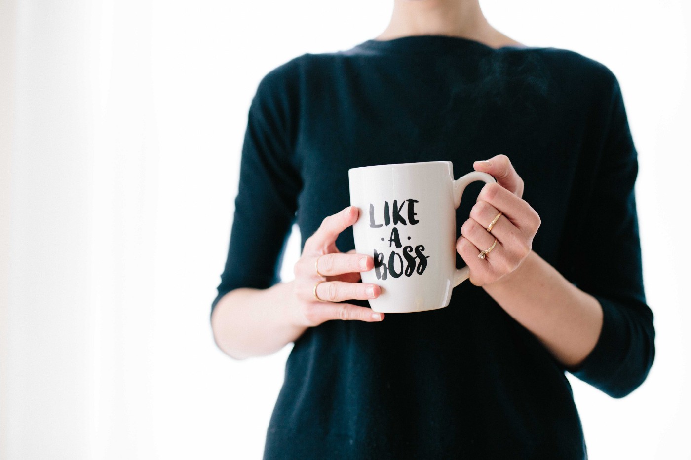 Woman holding white mug with Like a Boss on it