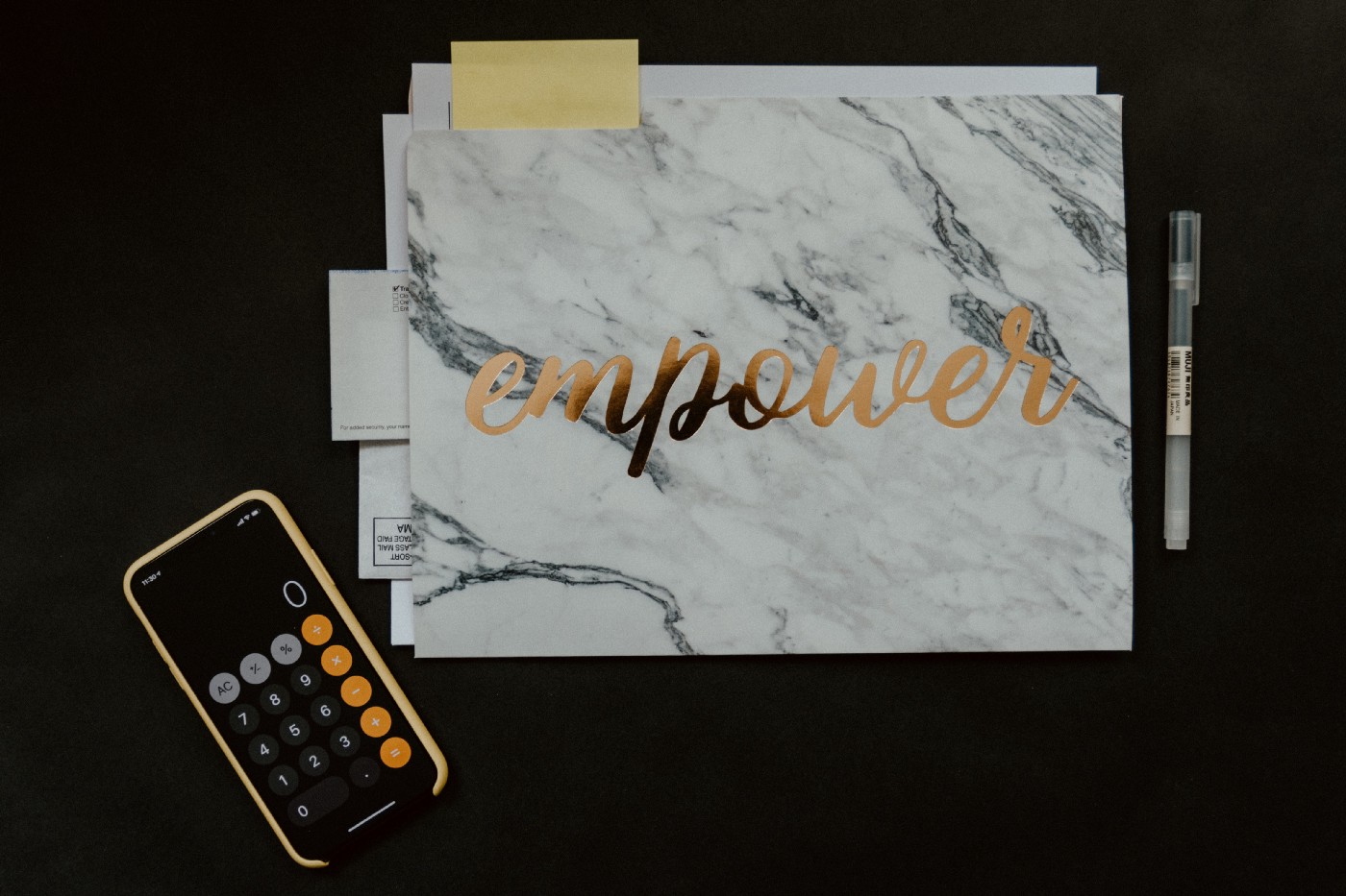 Folder with empower on it next to a pen and phone