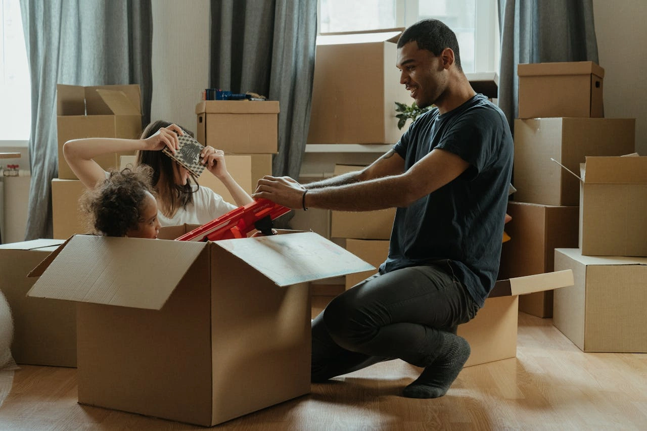 A family loading reusable moving boxes into a truck on moving day