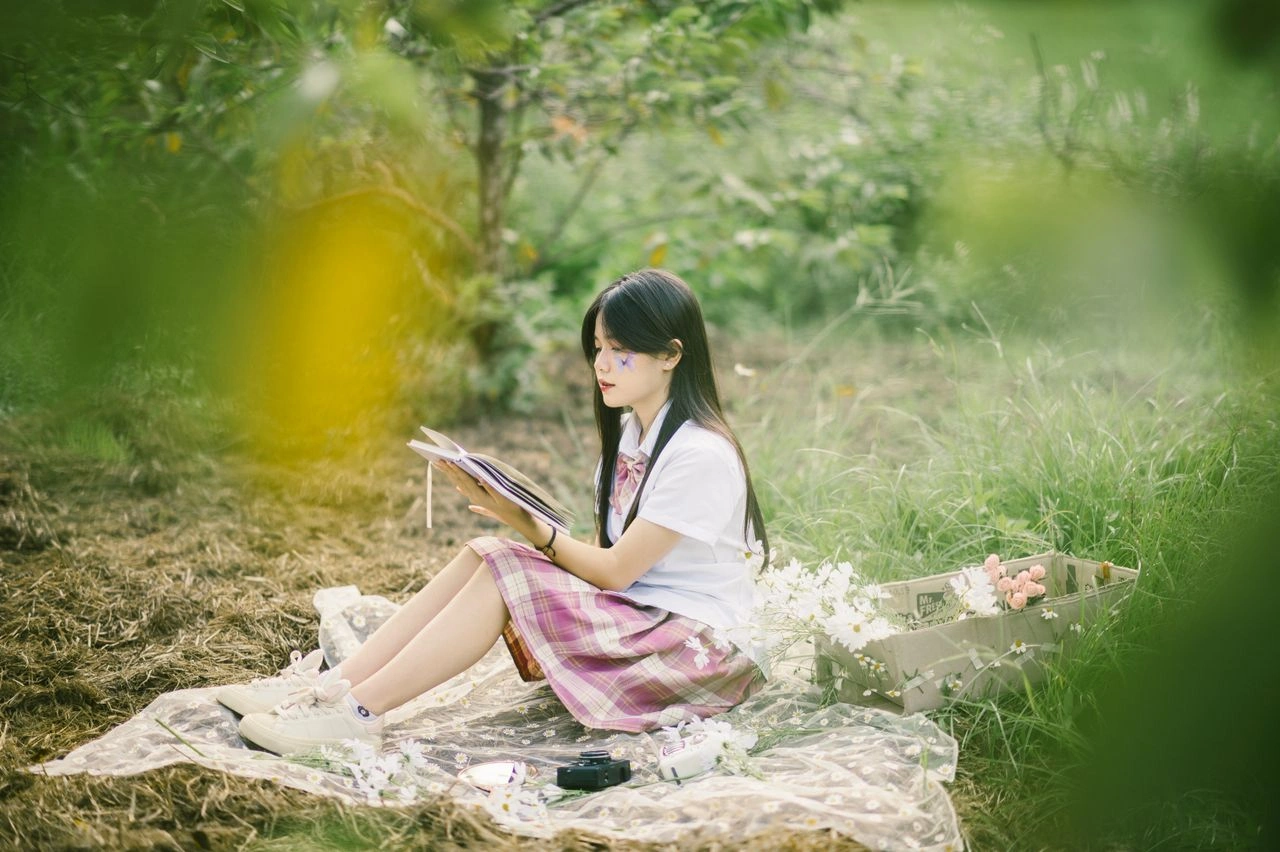 A serene outdoor scene of a young woman sitting in a meadow