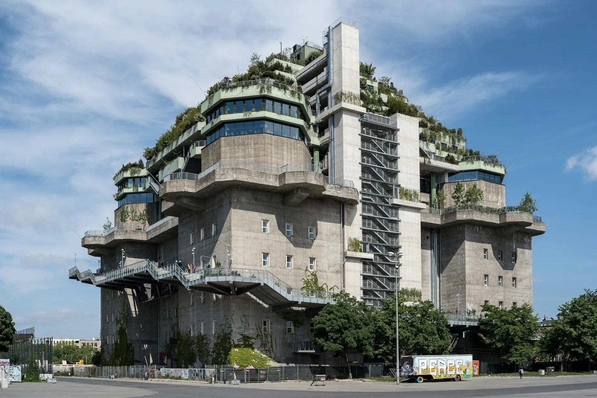 A massive concrete bunker building with rooftop gardens and external staircases