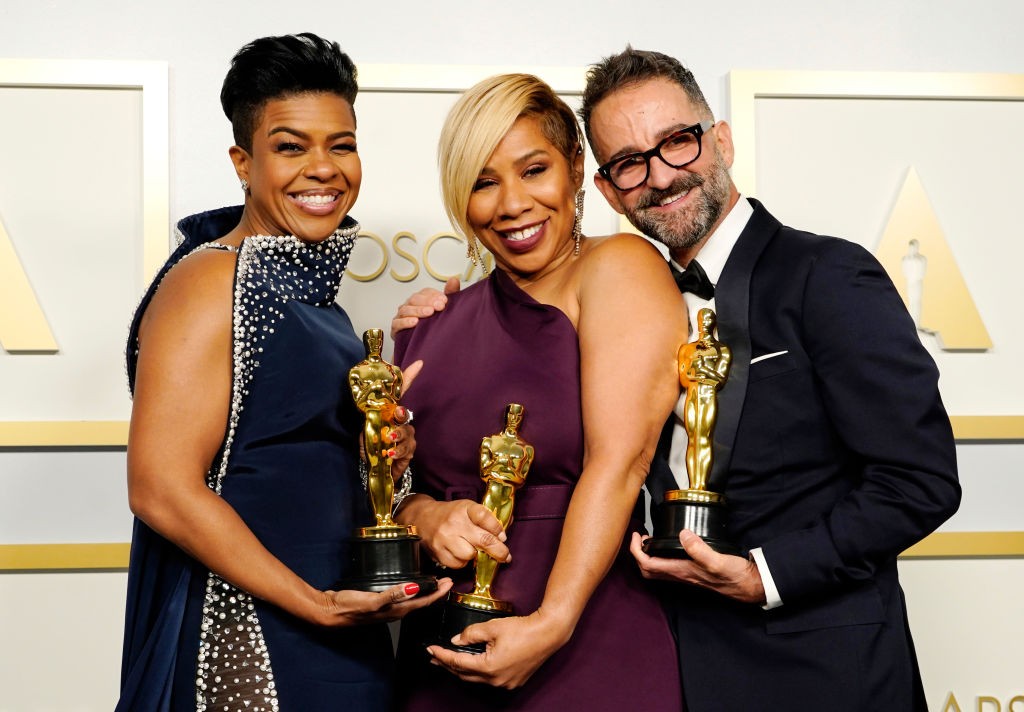 homem e duas mulheres negras inspiradoras segurando estatueta do oscar