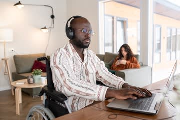 Homem em cadeira de rodas trabalhando no notebook