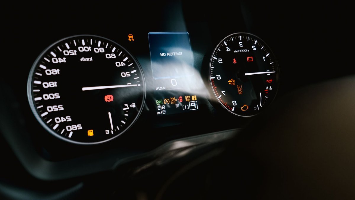 UK Drivers Often Ignore Critical Dashboard Warnings Detailed view of a car dashboard showing speedometer, tachometer, and warning lights, with ignition on.