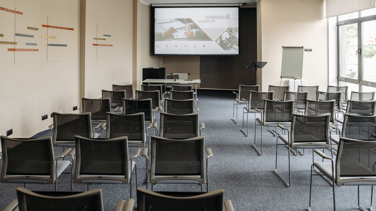 Empty conference room with chairs and a presentation screen setup for business meetings.