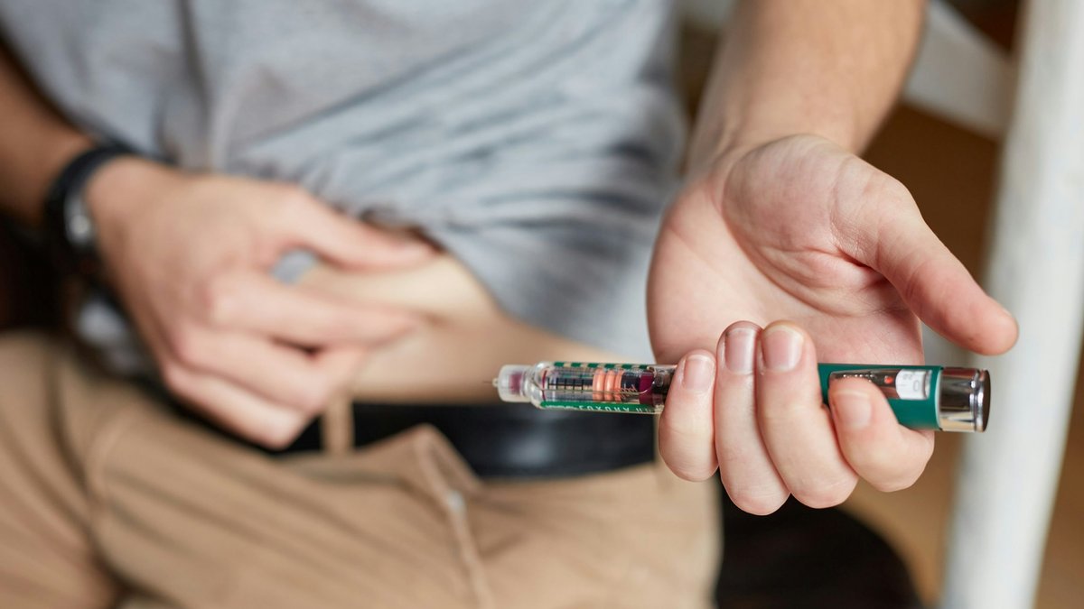 A person holding an insulin injection.