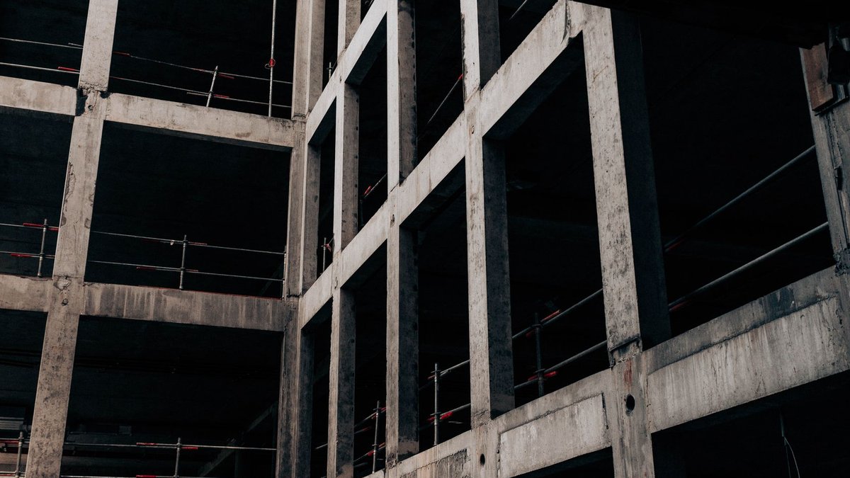 Experion Developers to invest Rs 10000 crore in NCR real Low angle of unfinished abandoned building with concrete walls at construction site in industrial area.