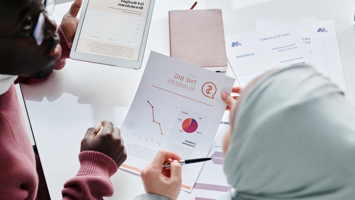 S&P places Meta rating outlook on negative Two colleagues reviewing financial documents and graphs during an office meeting.