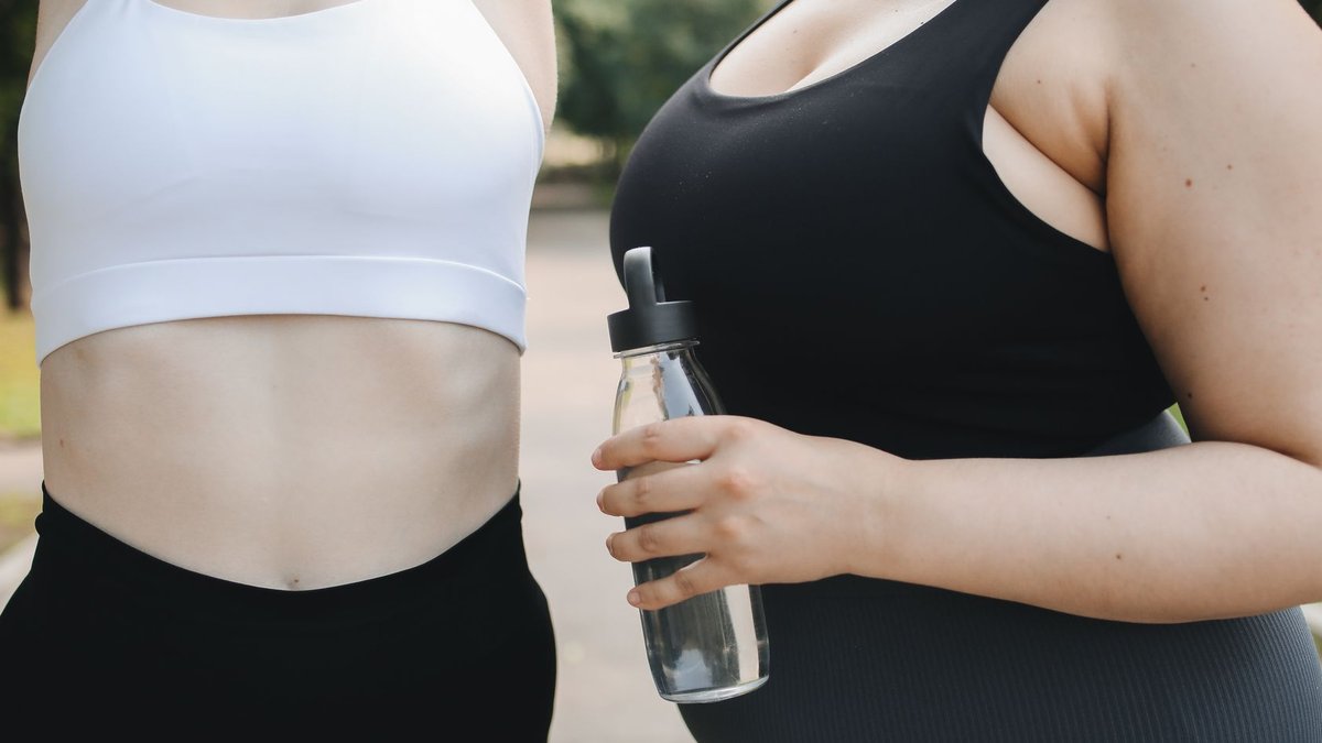 Two diverse women in activewear working out outdoors, promoting body positivity and health.