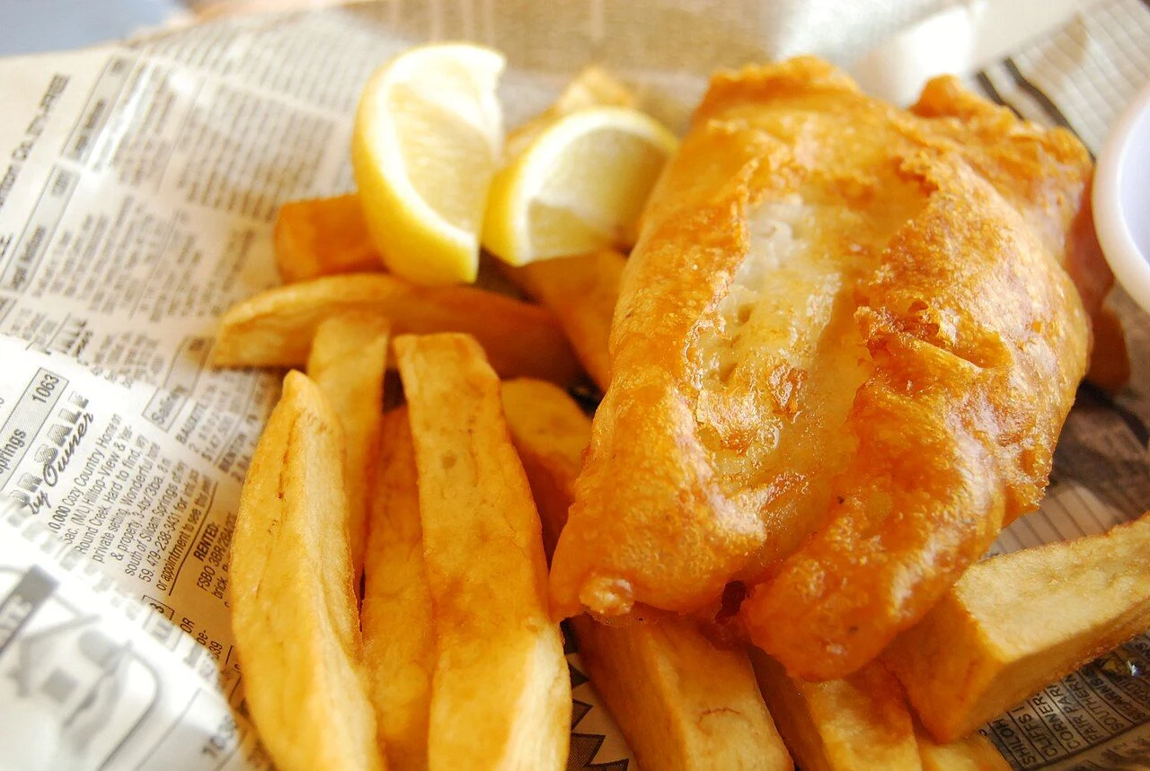 Classic fish and chips served with lemon in newspaper-style wrapping