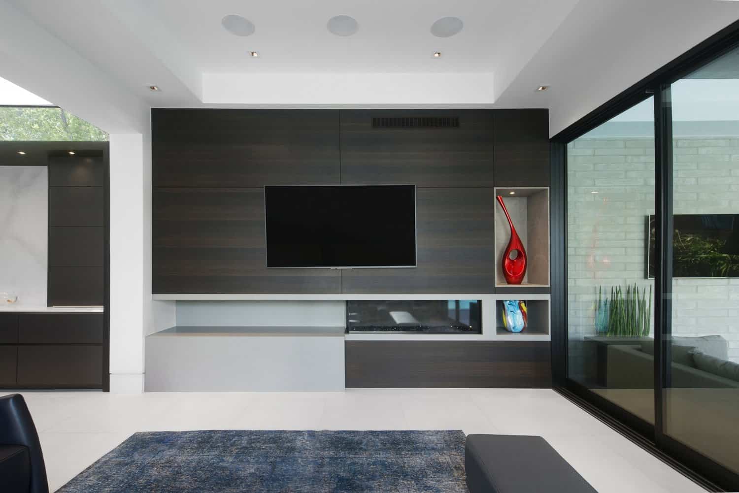 media room with eggersmann designed fireplace surround and display niches using a light concrete and dark wood to create interest