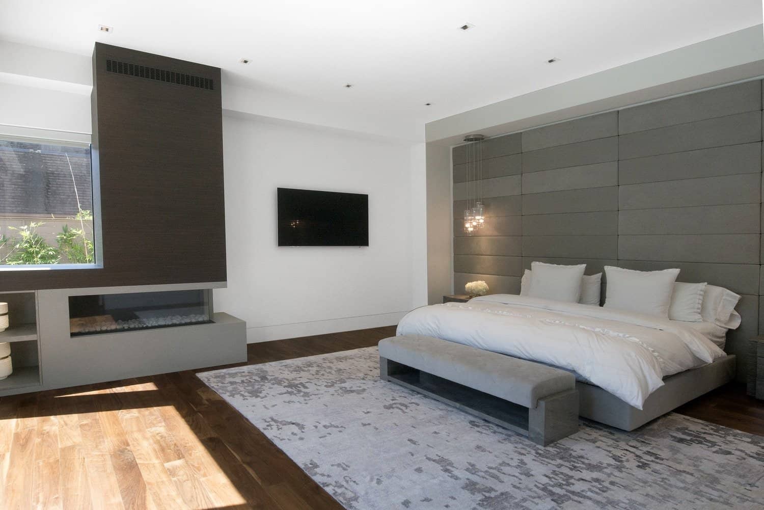 modern master bedroom with fireplace surround and niches designed by eggersmann