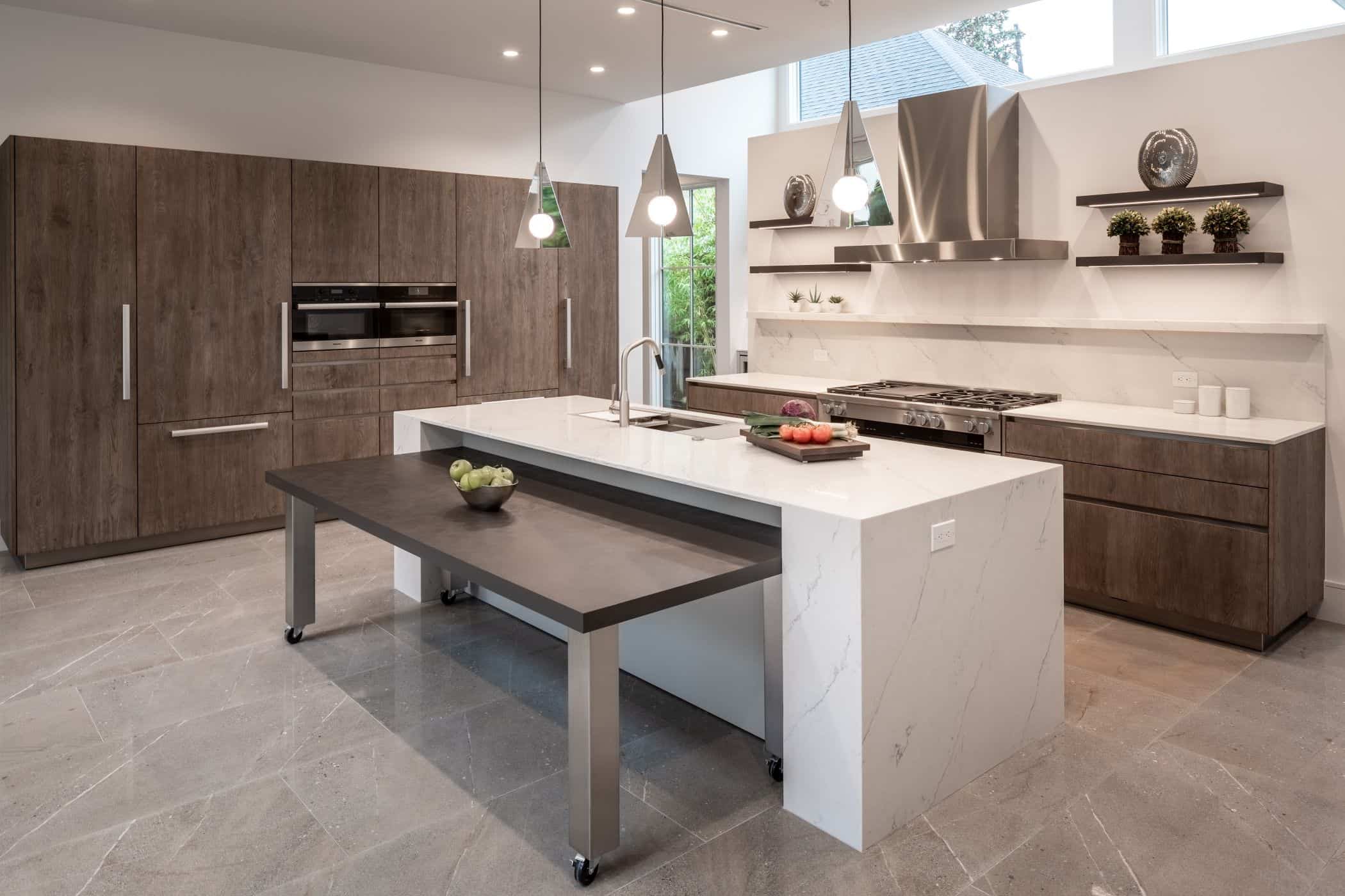 flexible nested dining table that stores under the island counter of an eggersmann kitchen in a washington coalition memorial park area home in houston
