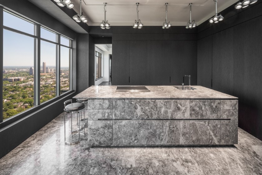 straight-on view of island and hidden wall cabinet storage in a luxury kitchen in the huntingdon luxury high-rise on kirby in houston