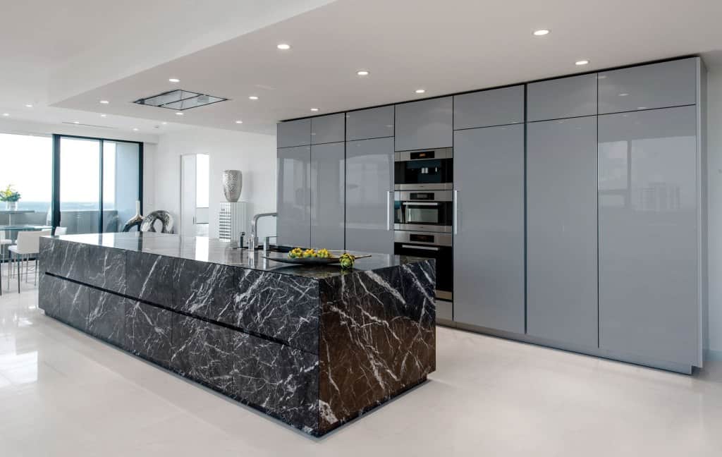 high gloss gray kitchen cabinets with stone island in grigio carnico limestone